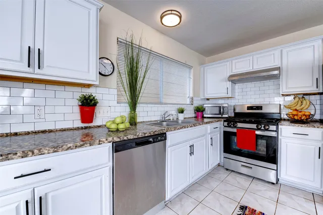 a kitchen with stainless steel appliances granite countertop a sink and cabinets