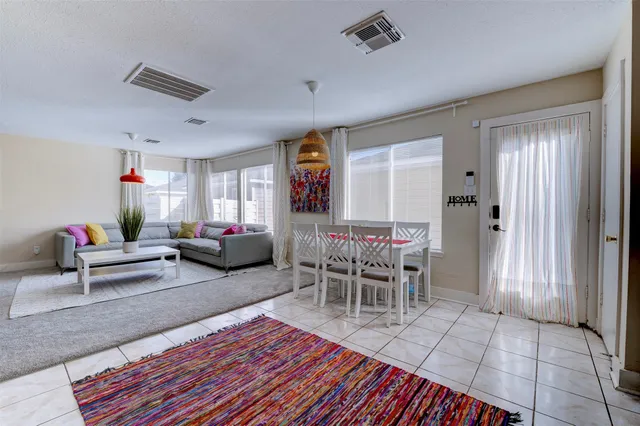 a living room with furniture a dining table and a window