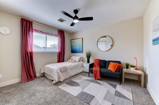 a spacious bedroom with a bed and a chandelier