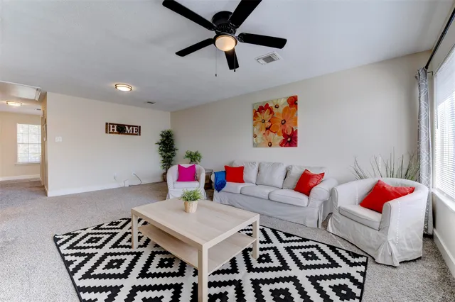 a living room with furniture rug and a window