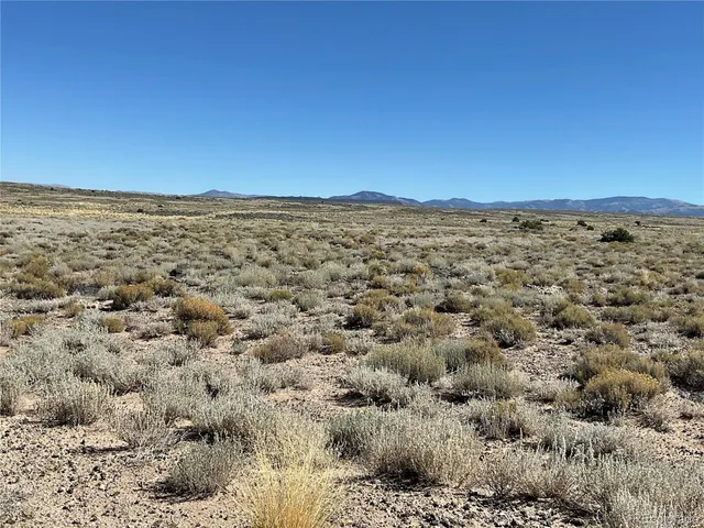 a view of a large mountain with mountains in the background