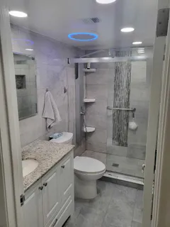 a bathroom with a granite countertop sink a toilet and shower