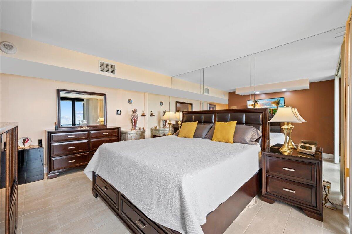 2400 Presidential Way, Unit 1204 West Palm Beach, FL 33401 - Photo 23 of 55 a bedroom with a bed and wooden floor