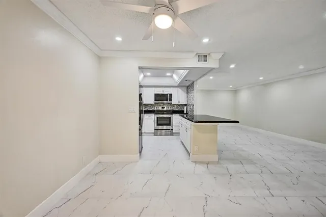 a view of kitchen with cabinets and window