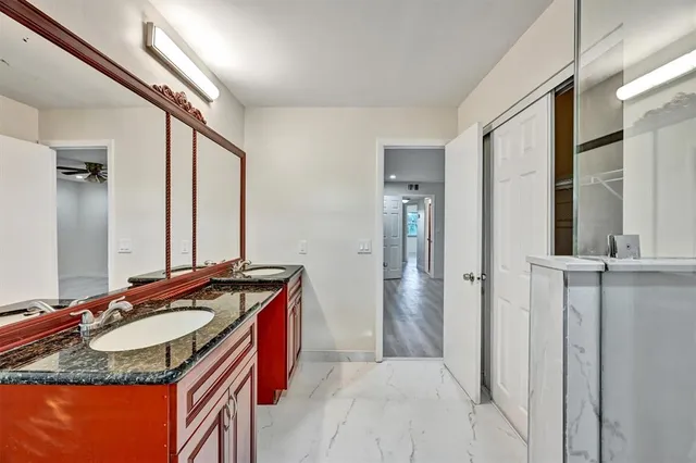 a bathroom with a granite countertop sink and a mirror