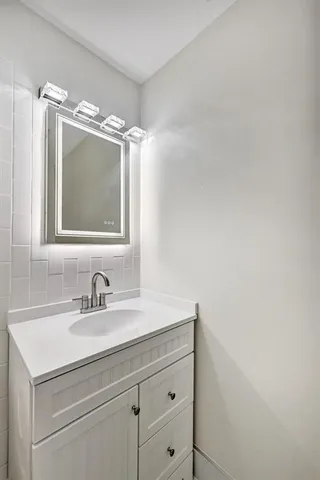 a bathroom with a sink vanity and mirror