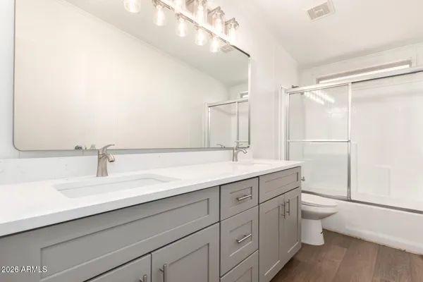 a bathroom with a double vanity sink toilet and a mirror