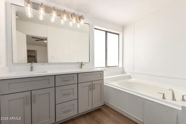 a bathroom with a tub a sink and mirror