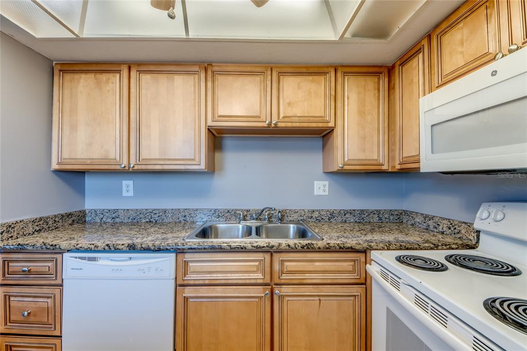 1003 Tropic Terrace North Fort Myers, FL 33903 - Photo 12 of 35 a kitchen with stainless steel appliances granite countertop white cabinets and a stove top oven