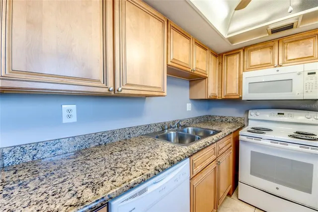 a kitchen with granite countertop a sink and cabinets