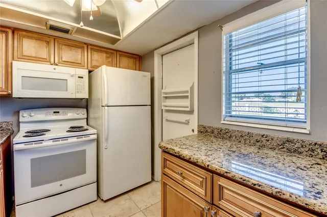 a kitchen with a stove window and refrigerator