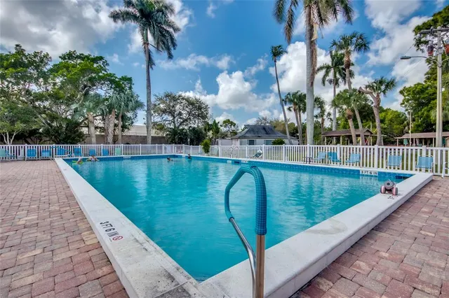 a view of a swimming pool with a patio and a yard