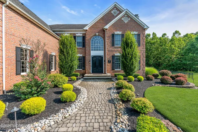 a front view of a house with a yard and potted plants
