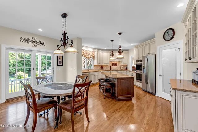 a kitchen with stainless steel appliances granite countertop a refrigerator a stove and a sink