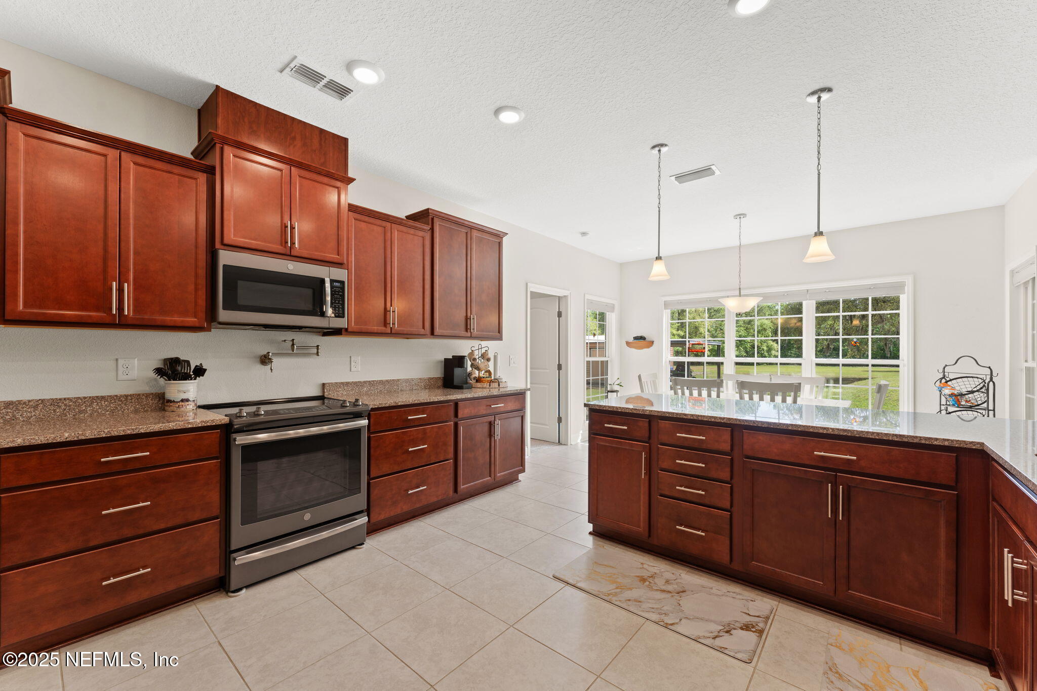 12869 Boney Road Jacksonville, FL 32226 - Photo 29 of 62 a kitchen with stainless steel appliances granite countertop wooden cabinets a stove a sink and dishwasher with wooden floor