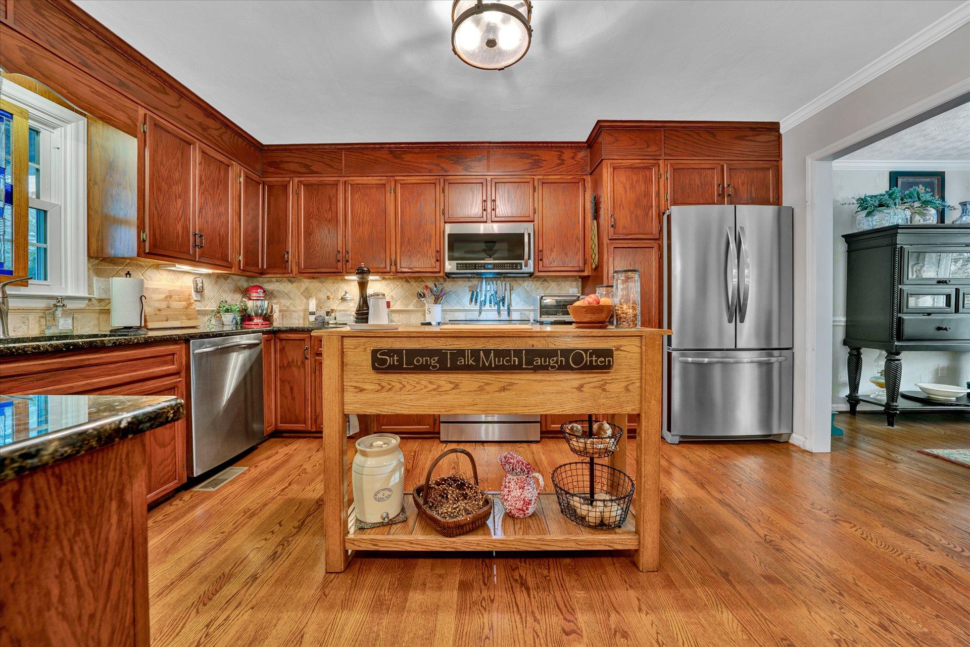 307 North Preston Road Vinton, VA 24179 - Photo 17 of 48 a kitchen with stainless steel appliances granite countertop a refrigerator a stove and a wooden floors