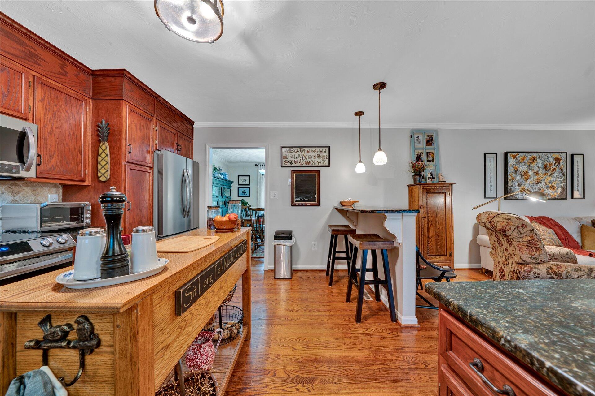 307 North Preston Road Vinton, VA 24179 - Photo 18 of 48 a kitchen with stainless steel appliances granite countertop a sink dishwasher stove top oven a dining table and chairs with wooden floor