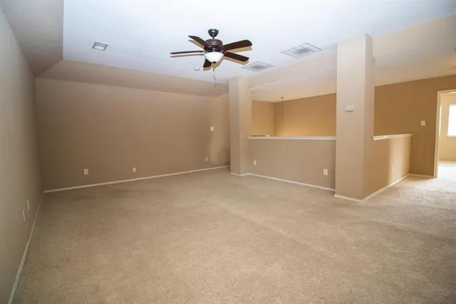 a view of a room with a ceiling fan and a window