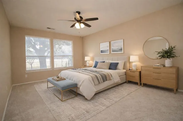 a spacious bedroom with a bed and a chandelier