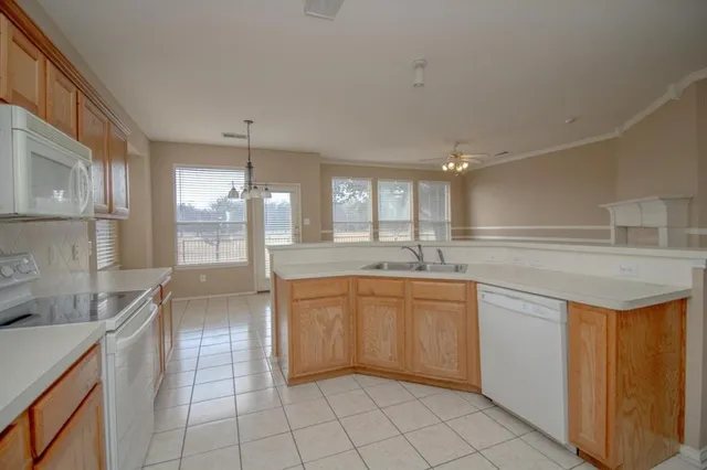 a large kitchen with granite countertop a sink and cabinets