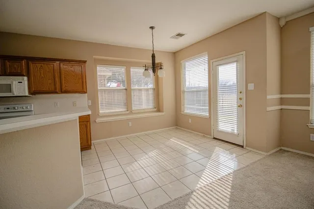 a view of an empty room with window and cabinet