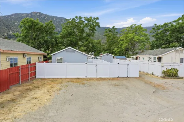 a view of a house with a yard and mountain view in front of it