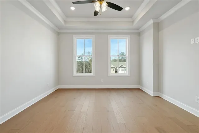 an empty room with a window and a ceiling fan