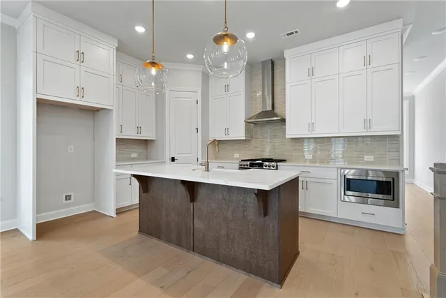 a kitchen with kitchen island granite countertop a sink a stove and cabinets