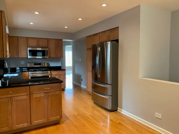 a kitchen with stainless steel appliances granite countertop a refrigerator and a stove top oven