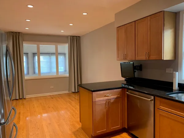 a view of a kitchen with wooden floor and cabinets