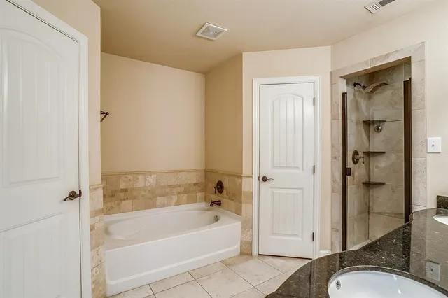 a bathroom with a granite countertop bathtub shower and a sink