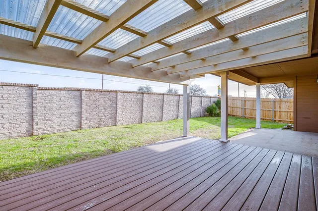 a view of an empty room with wooden floor and fence