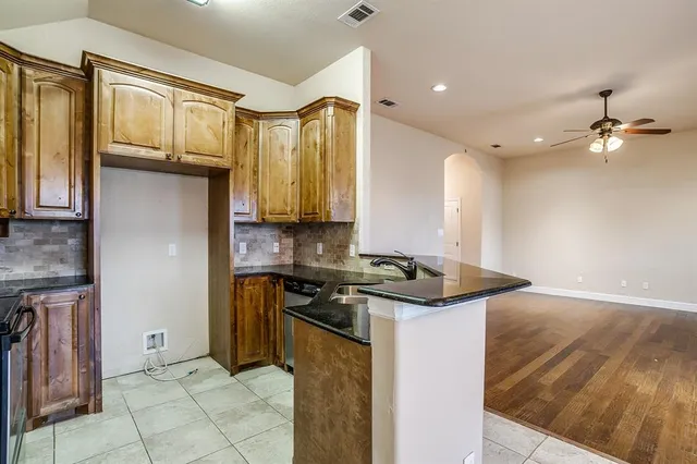 a kitchen with stainless steel appliances granite countertop a stove a sink and a microwave