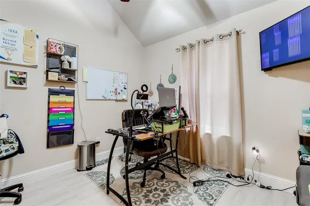 a view of a workspace with furniture and a window