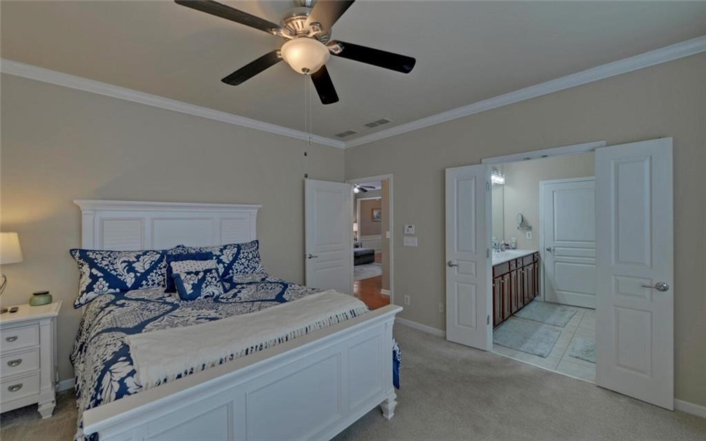 6213 Azalea Way Hoschton, GA 30548 - Photo 20 of 56 a bedroom with a bed and a chandelier