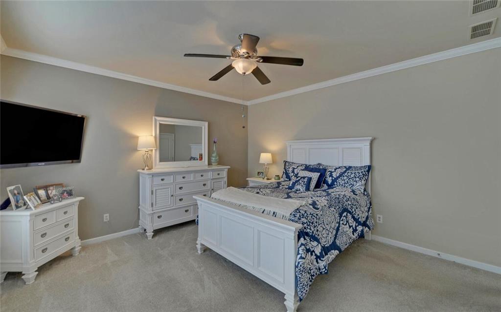 6213 Azalea Way Hoschton, GA 30548 - Photo 21 of 56 a bedroom with a bed and a flat tv screen on dresser