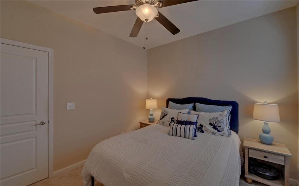 6213 Azalea Way Hoschton, GA 30548 - Photo 30 of 56 a bedroom with a bed and a chandelier