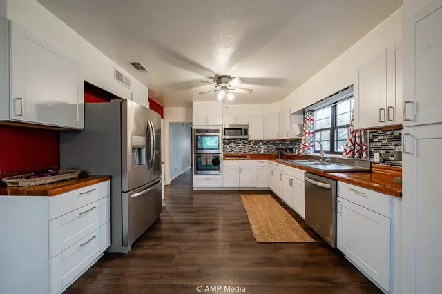 a kitchen with white cabinets and sink