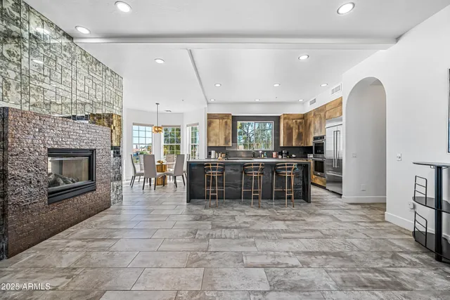 a living room with furniture a fireplace and a large window