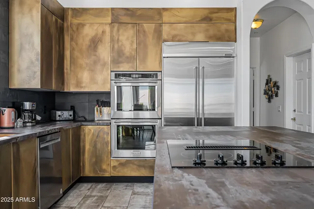 a view of kitchen with stainless steel appliances granite countertop a stove top oven a granite counter space and a sink