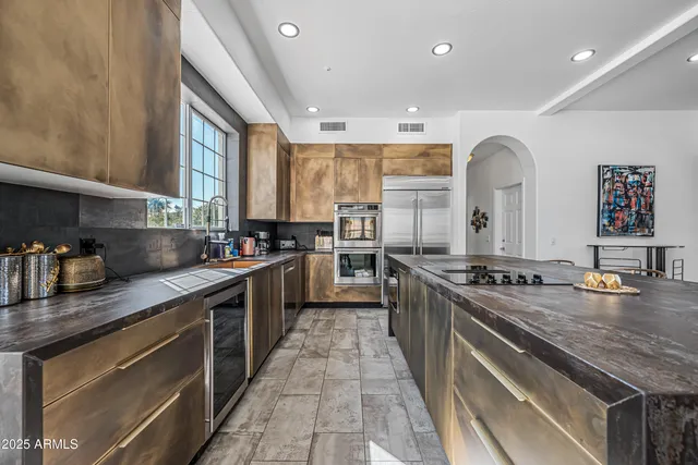 a kitchen with stainless steel appliances granite countertop a stove a sink and a microwave