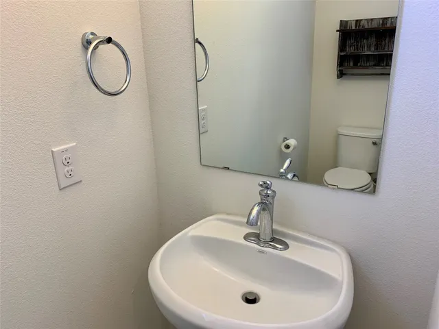 a bathroom with a sink mirror and toilet