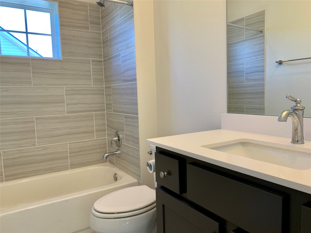 5205 Samuel Huston Avenue, Unit B Austin, TX 78721 - Photo 19 of 37 a bathroom with a granite countertop sink toilet and bathtub