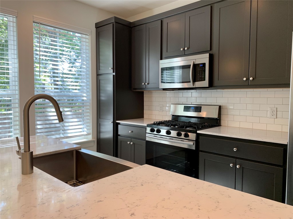 5205 Samuel Huston Avenue, Unit B Austin, TX 78721 - Photo 22 of 37 a kitchen with a stove a sink and a microwave