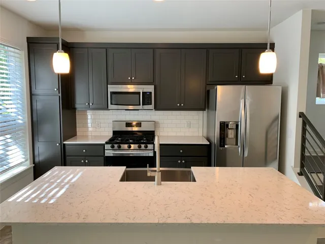 a kitchen with a stove a sink and a microwave