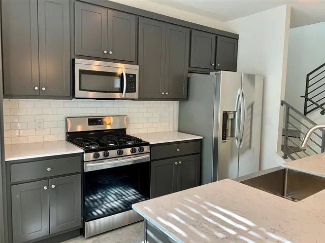 a kitchen with kitchen island a counter top space appliances and cabinets