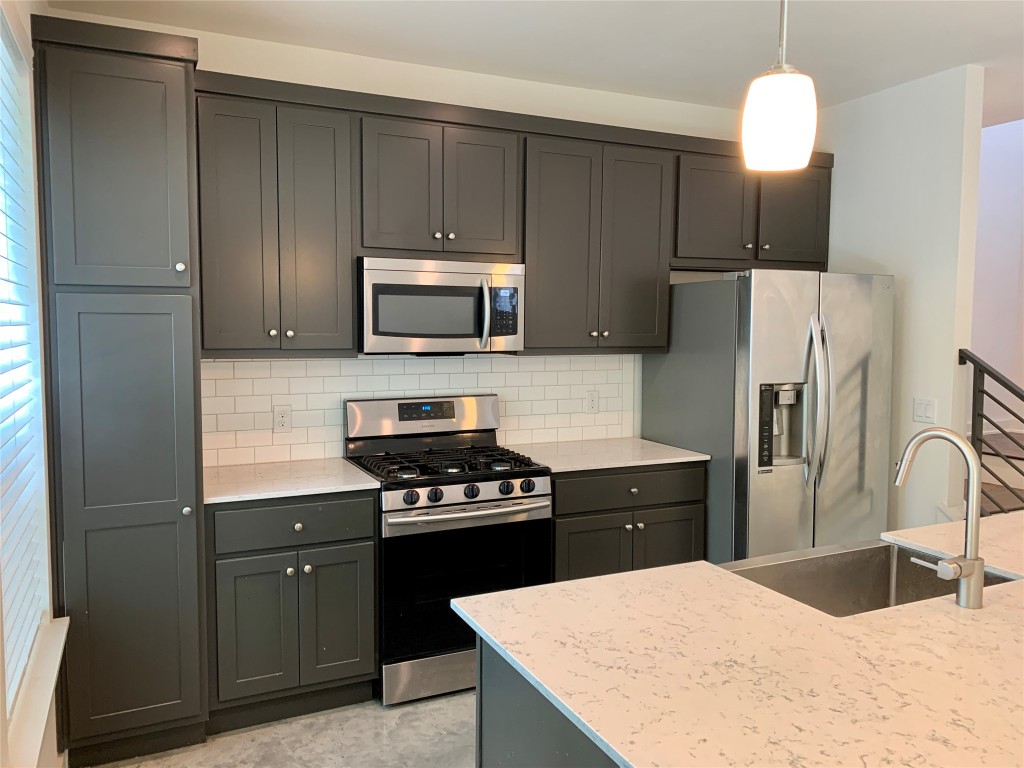 5205 Samuel Huston Avenue, Unit B Austin, TX 78721 - Photo 8 of 37 a kitchen with granite countertop a refrigerator stove and microwave