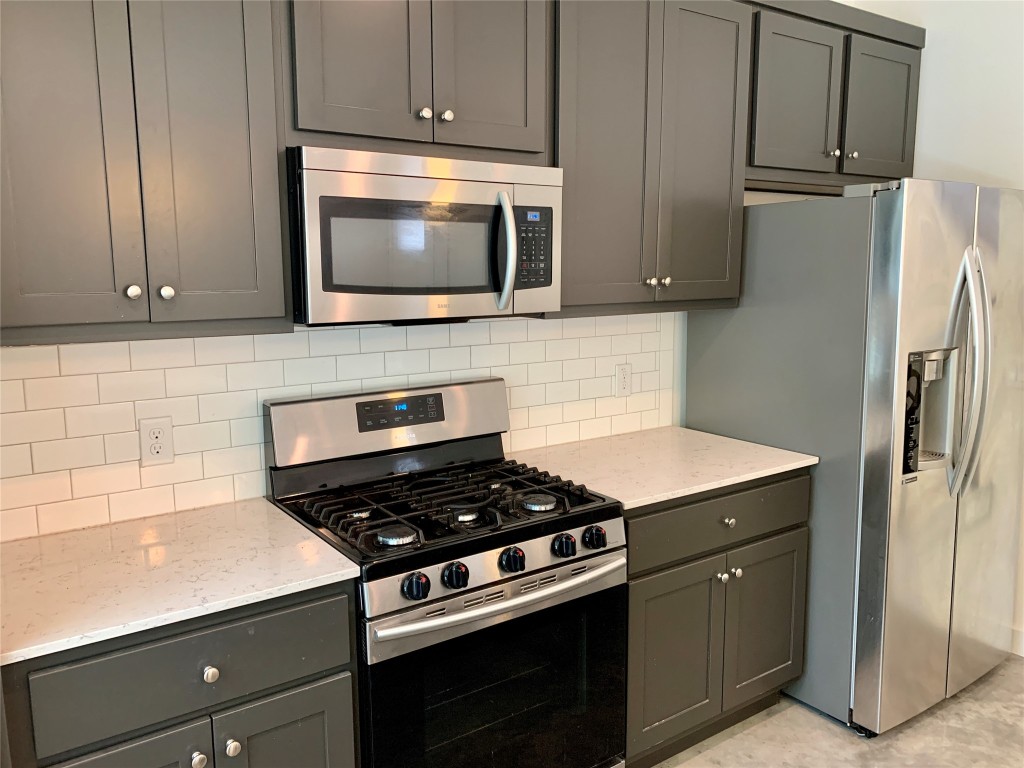 5205 Samuel Huston Avenue, Unit B Austin, TX 78721 - Photo 9 of 37 a kitchen with stainless steel appliances white cabinets and a stove top oven