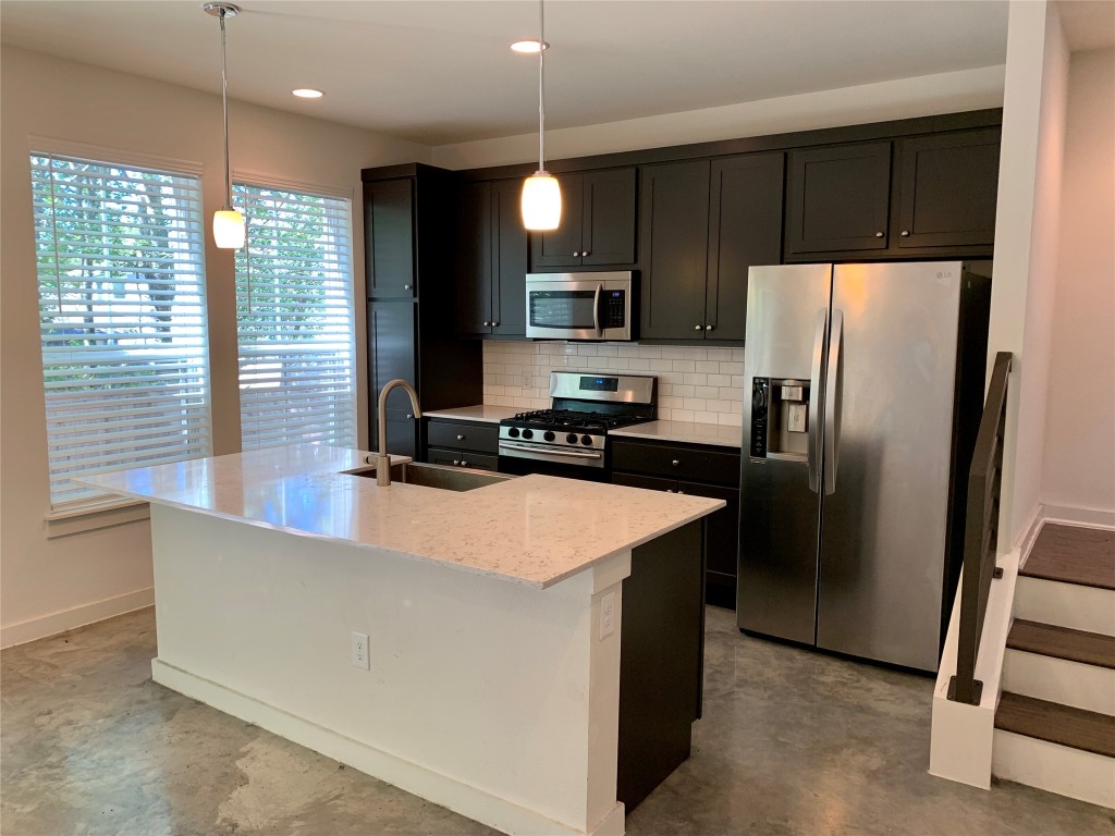5205 Samuel Huston Avenue, Unit B Austin, TX 78721 - Photo 10 of 37 a kitchen with stainless steel appliances granite countertop a refrigerator a sink a stove and a refrigerator