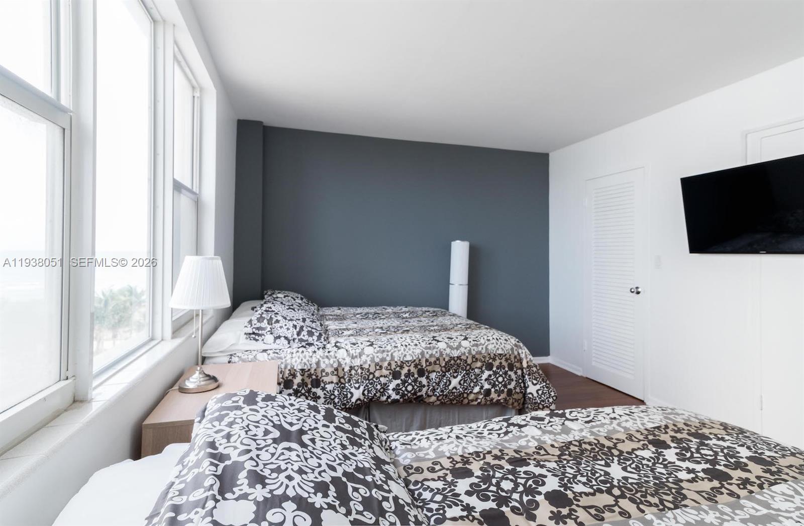 9195 Collins Avenue, Unit 611 Surfside, FL 33154 - Photo 12 of 33 a bedroom with a bed and a flat screen tv